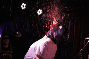 band member spitting fake blood into air
